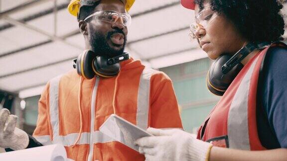 工业工程师穿着安全帽和安全外套在工厂工作