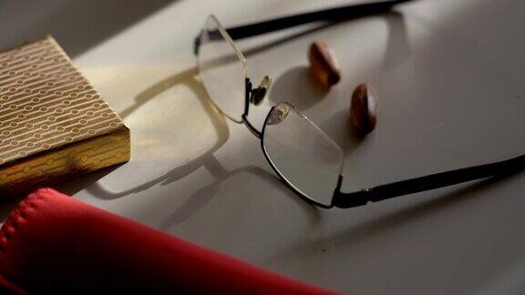 眼镜放在一个轻的桌子上和影子的运动