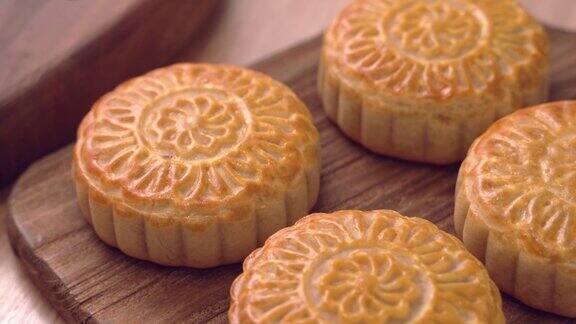 为庆祝中国传统的中秋节在木制托盘上烘焙的粤式月饼糕点