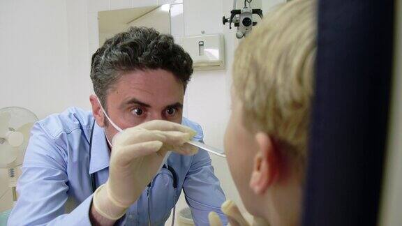 儿科医生用压舌板检查儿童的喉咙