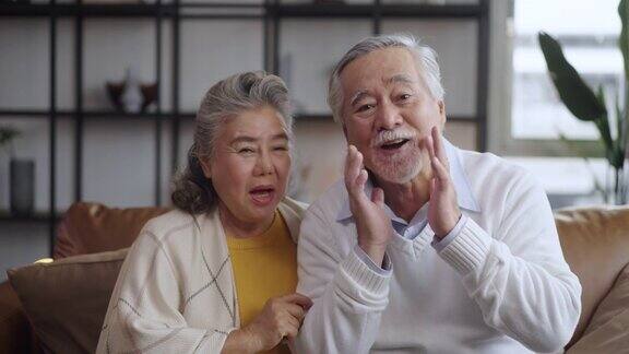 亚洲成熟的老夫妇在家里看着摄像机说话在线聊天中的视频通话