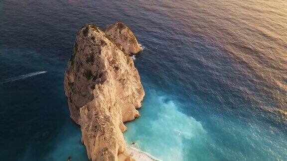 无人机拍摄的希腊扎金索斯的爱奥尼亚海岸岩石山脊漂浮的船蓝色的水日落