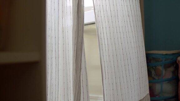 房间的窗户上挂着白色窗帘