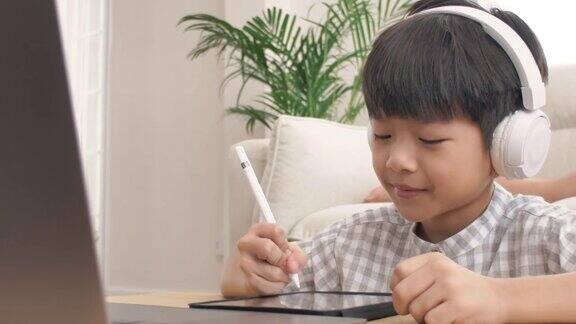 小男孩用笔记本电脑在家上网课