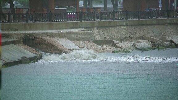 肮脏的洪水从城镇排水管道排入港口的海中