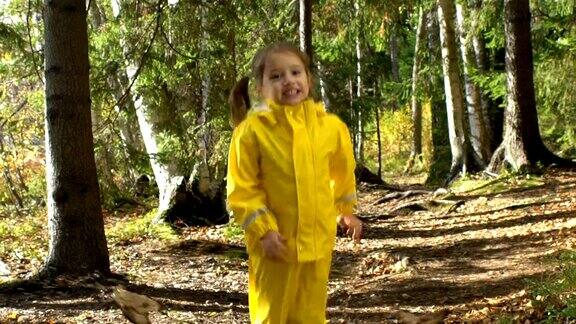 穿着黄色橡皮服的小女孩正在水坑里跳慢动作