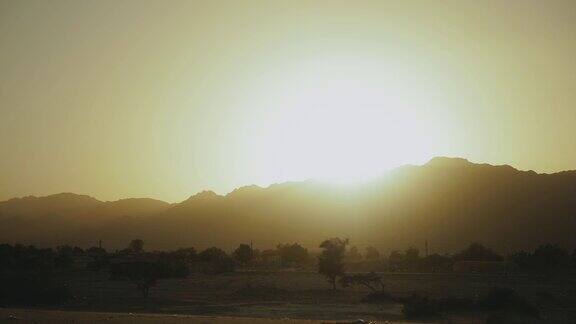 令人惊叹的日落在埃及沙漠山脉地平线下的阳光照亮了山影之上的天空慢镜头4k