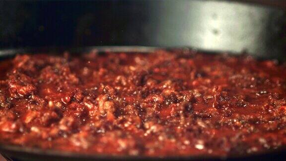 超级慢动作肉在煎锅里煎用高速摄像机以每秒1000帧的速度拍摄