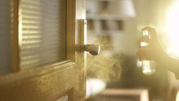 小女孩用抗菌喷雾给门把手消毒