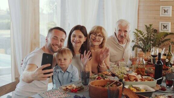 欢乐的家庭用智能手机自拍假日晚餐