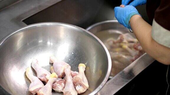 特写镜头烹饪工人戴着防护手套在烹饪前清洗生鸡腿健康食品志愿服务和慈善机构covid-19后重新开放安全