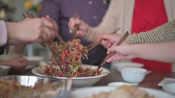 亚洲华人多代家庭庆祝中国新年前夕与传统食物娄桑(生鱼菜肴)团圆饭