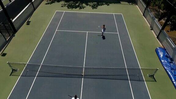 两个年轻人在室外网球场打网球