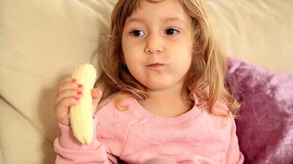 可爱的小女孩在吃香蕉