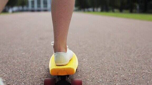 十几岁的女孩脚骑短现代滑板