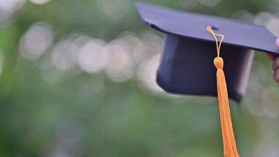 黑色的毕业生帽子和黄色的流苏贴在旧木头上