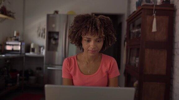 年轻女子在家里使用笔记本电脑工作