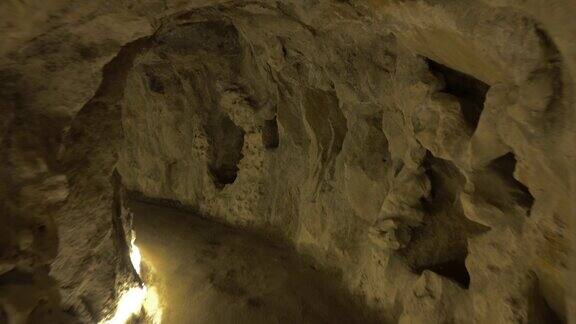 走在岩石挖成的黑暗隧道里