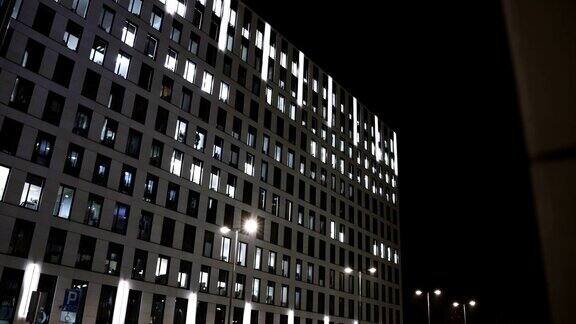 办公大楼现代玻璃和混凝土摩天大楼剪影晚上加班