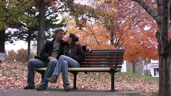 一对夫妇坐在公园长椅上