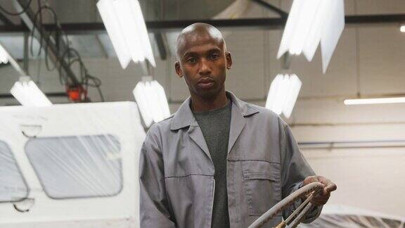 非裔美国男性汽车修理工拿着方向盘看着镜头
