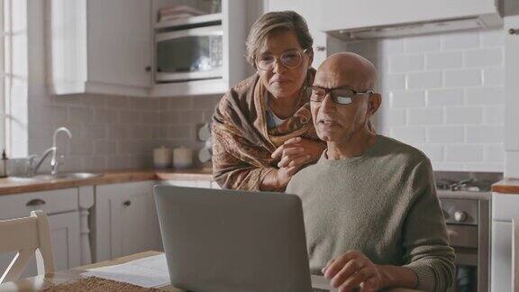 一对老夫妇在家里用笔记本电脑的4k视频片段