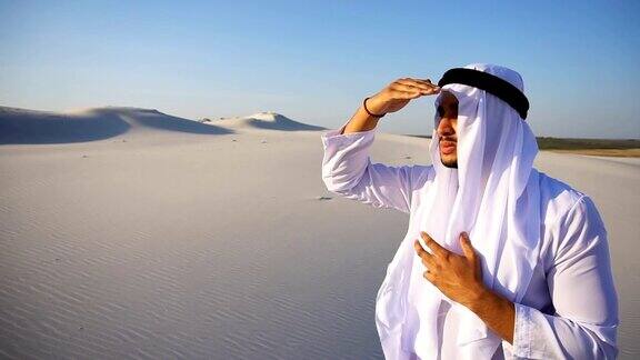 夏日里站在广阔的沙漠中威严的阿拉伯阿联酋酋长凝视远方沉思