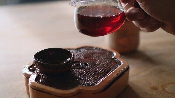 在茶道上男子把茶倒进一个陶碗里中国茶道