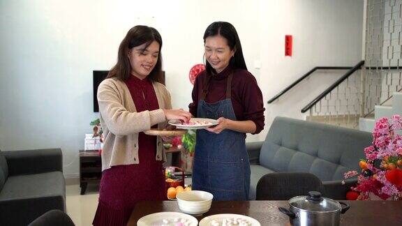 两位亚洲妇女正在做汤圆作为中国新年的团圆饭