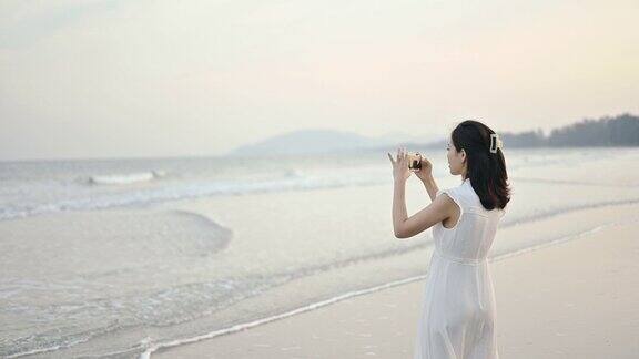 快乐的亚洲妇女享受日落漫步热带海滩海边享受日出