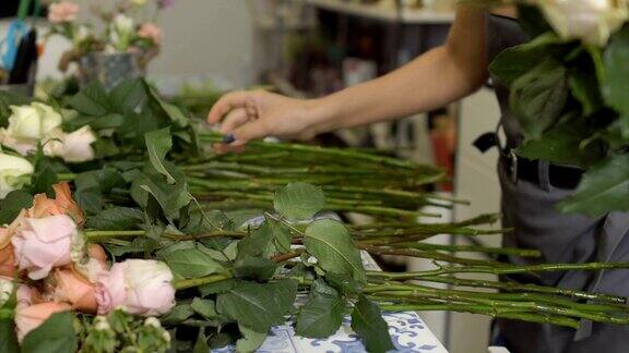 花店里的花匠把玫瑰花捧成一束