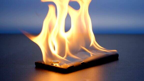 慢镜头:晚上智能手机躺在桌子上燃烧着