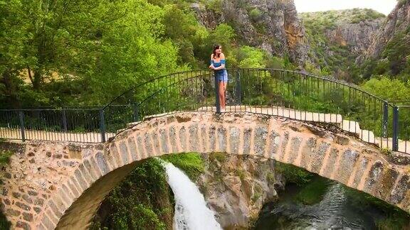 鸟瞰历史桥和瀑布峡谷和水从桥上流动桥与森林中的美景瀑布与桥弗里吉亚桥美女在桥上看风景女人在桥上