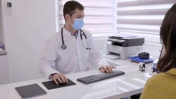 医生戴上防护口罩为病人打字并打印报告