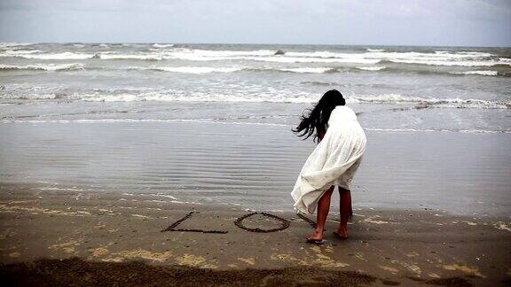 在沙滩上写爱情的女人