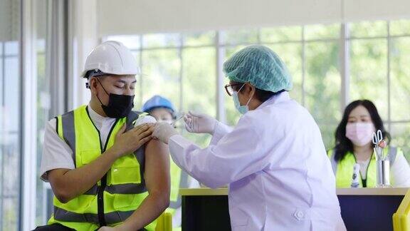 建筑行业COVID-19疫苗接种站医生正在接种疫苗以保护在医院的工程工人保护COVID-19或流感人们戴口罩以防止病毒感染健康福利