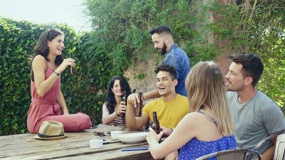 朋友们在户外庭院喝啤酒社交的慢动作视频