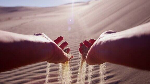 女性手中握着干热的沙漠沙粒