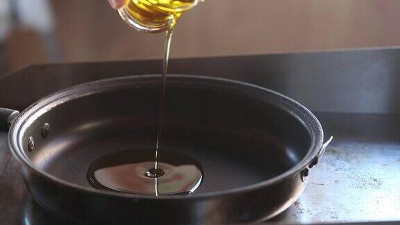 厨师将橄榄油倒在平底锅上