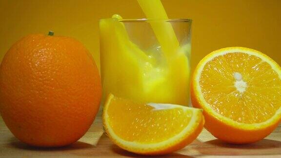 新鲜甜橙汁倒在一个玻璃杯里旁边是成熟的橙子