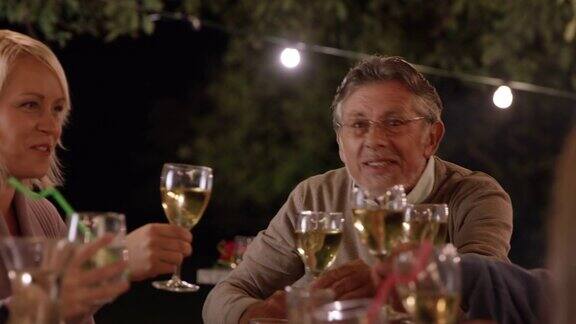 一个老人在晚上的野餐上提议祝酒