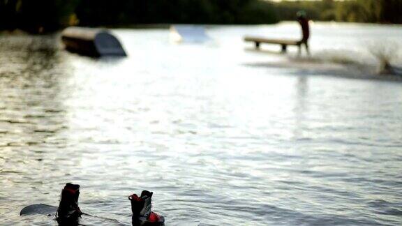 尾流板漂浮在水面上背景中一名男子骑着尾流板