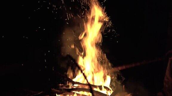 在户外旅游营地的篝火在山上火焰和火焰火花在黑暗抽象的背景燃料、动力和能源