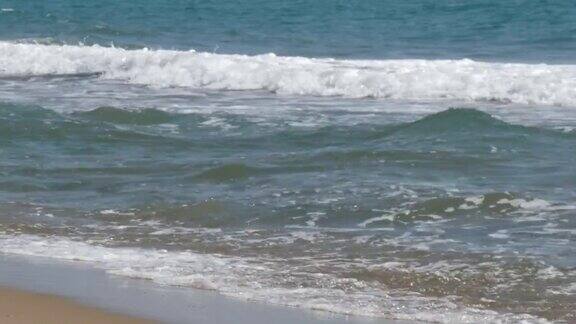 地中海的海浪拍打着西班牙海滩上的沙子