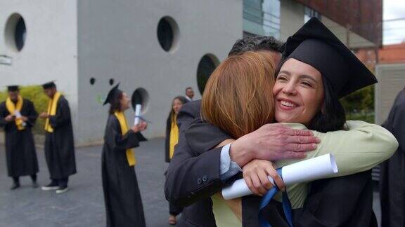 在毕业典礼上快乐的毕业生拥抱她的父母看起来很兴奋