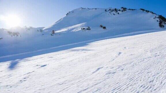 滑雪者在阳光明媚的日子冲下滑雪道