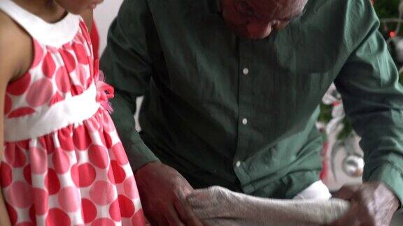 慈爱的爷爷从孙女那里收到圣诞礼物拥抱着孙女非常高兴
