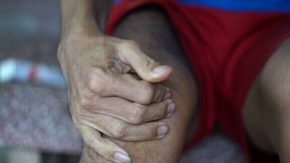 男人用按摩丸按摩膝盖以减轻疼痛