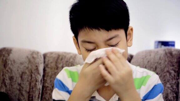 亚洲小孩感冒打喷嚏用纸巾擦干净