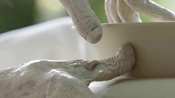 手在陶轮上工作塑造一个陶瓷
